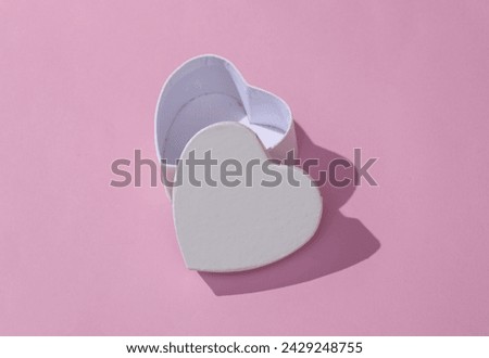 Empty white box in the shape of a heart on pink background