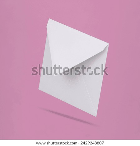 White empty envelope levitating on pink background with shadow