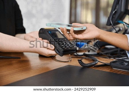 cropped african american woman using smartphone for mobile payment at hotel reception, travel Royalty-Free Stock Photo #2429252909