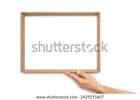 Male hand holds an empty picture frame on white background, including clipping path