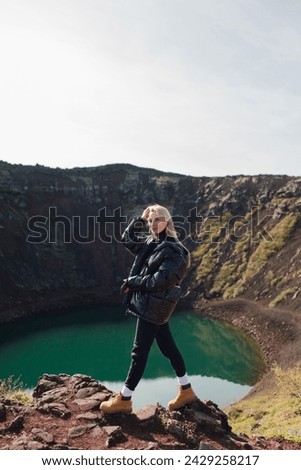 Traveling and exploring Iceland landscapes and travel destinations. Young traveler enjoying the view of beautiful nature.  Female tourist watching spectacular scenery. Summer tourism by Atlantic ocean