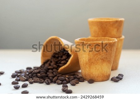 Edible cookie coffee cup filled with coffee bean, eco friendly alternative for takeaway cup. Royalty-Free Stock Photo #2429268459