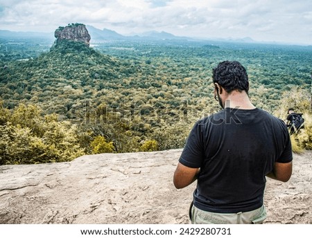 Photographers taking pictures of Sigiriya Rock Castle from the top of Pidurangala Rock in Sri Lanka.