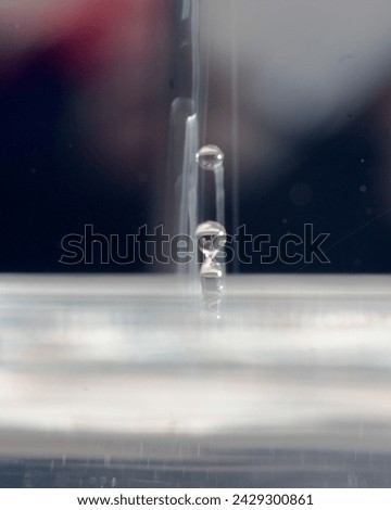 abstract picture with colored drop of various shapes, blurred background, water drop splash, close focus, grainy water texture