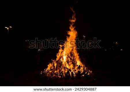 Large bonfires are lit at night as part of popular and ancestral celebrations in the squares of villages and cities from the Mediterranean Royalty-Free Stock Photo #2429304887