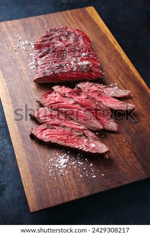 Traditional American barbecue bavette steak with salt and pepper served as close-up on a wooden design board  Royalty-Free Stock Photo #2429308217