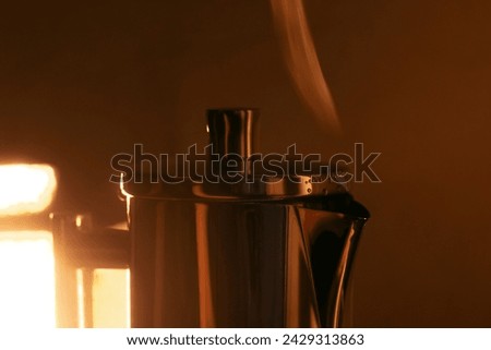 Close up view of top part of the geyser coffee maker on the stove with the steam comes out of the spout Royalty-Free Stock Photo #2429313863