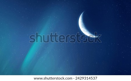 Northern lights and bright moon in the night sky.