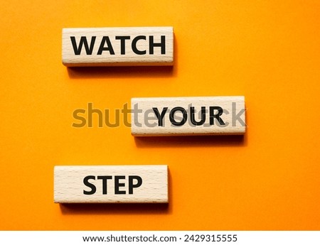 Watch your Step symbol. Concept words Watch your Step on wooden blocks. Beautiful orange background. Business and Watch your Step concept. Copy space.
