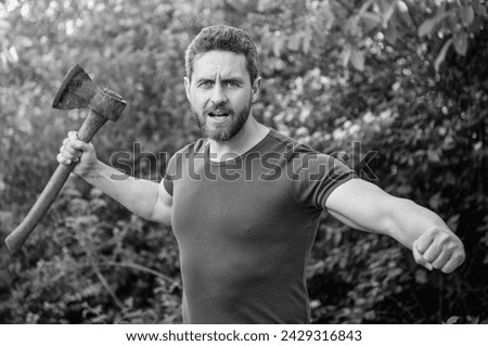 man threatening with hatchet. man threatening with hatchet wearing shirt. man threatening Royalty-Free Stock Photo #2429316843