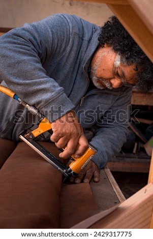 Master upholsterer at work, job portrait. Royalty-Free Stock Photo #2429317775