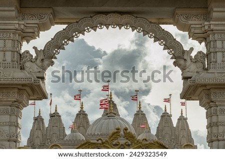 Entrance archway of the Neasden temple (BAPS Shri Swaminarayan Mandir) against a nice cloud sky background. Gates of Neasden Temple, Hindu temple in Neasden to build is constructed from Italian Marble