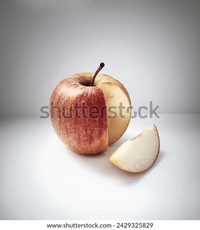 Fresh ripe apple with a cut piece on a white background