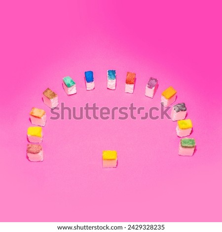 Colorful sugar cubes in the form of a crowd on a pink background. People metaphor. Creative food concept. 
