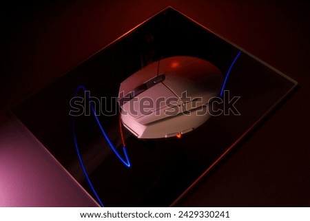 computer mouse in the dark on a mirror surface with light stripes in reflection. Long exposure photography. 