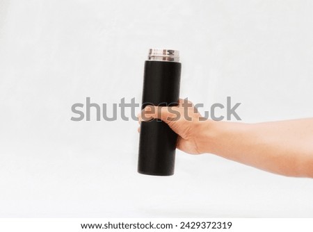 A man's hand holds a black thermos hot or cool drink Isolated on a White background