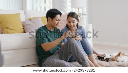 Asia people young family man woman smile happy fun laugh look at phone sit at home pay for hotel booking, search choose, buy ticket on social media app for budget travel abroad trip getaway plan tour.