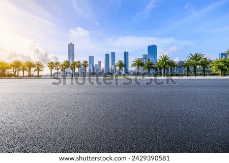 Asphalt road and city skyline with modern buildings under blue sky