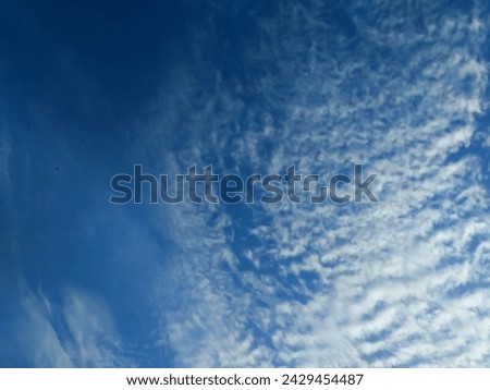 The view of a bright blue sky in the morning with clouds blowing in the wind depicts a happy atmosphere at the start of the morning