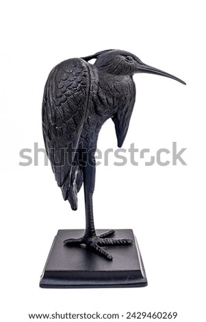 A purchased (consumer) pig iron bird figurine in close-up on a white background