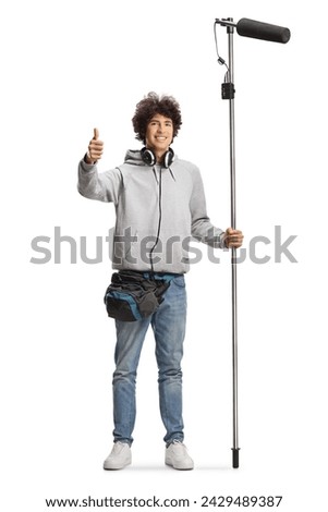 Boom operator with headphones holding a microphone and gesturing thumbs up isolated on white background
