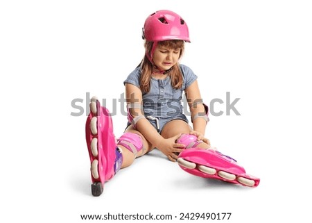 Sad girl with roller blades crying and sitting on the floor with an injured knee isolated on white background