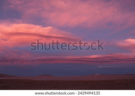 Scenic view of colorful sunset evening scenery with red and orange clouds at sky horizon in Eduardo Avaroa Andean Fauna National Reserve near Red Lagoon in Bolivia, South America. Royalty-Free Stock Photo #2429494135