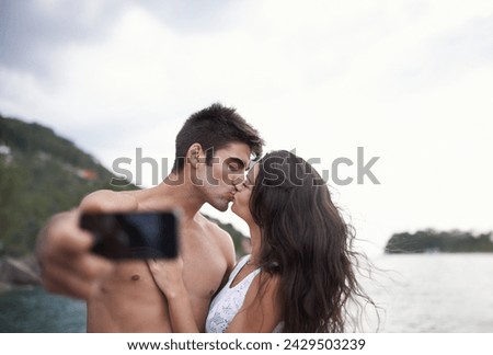 Kiss, selfie and couple at ocean for vacation, holiday or travel together outdoor. Photography, woman and man at sea for love, adventure and taking pictures for memory in summer by water in nature