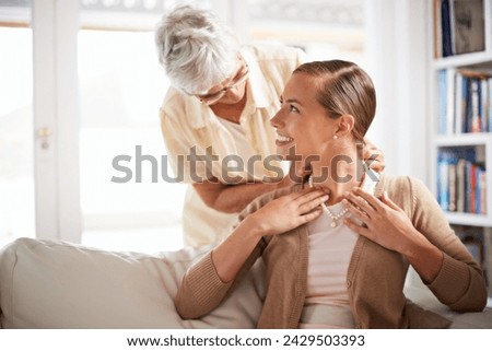 Love, necklace and senior mother with woman for gift, present and surprise in living room. Family jewels, home and happy daughter with mom giving pearls on sofa for celebration, birthday and bonding
