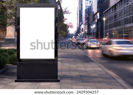 Blank advertising billboard on city sidewalk, evening traffic on street, urban marketing mockup, vehicles passing by, pedestrian path.