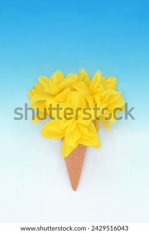 Surreal ice cream cone with spring and easter daffodil flowers on gradient blue white background. Fun food nature floral spring design.