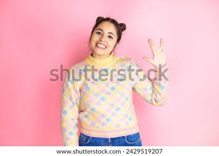 Young beautiful woman wearing casual sweater over isolated pink background doing star trek freak symbol