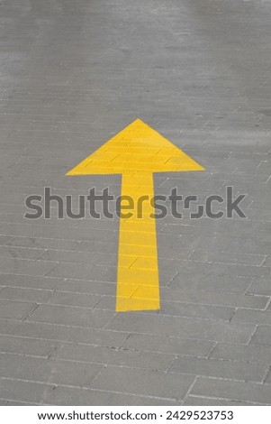 Yellow road arrow indicating direction for traffic