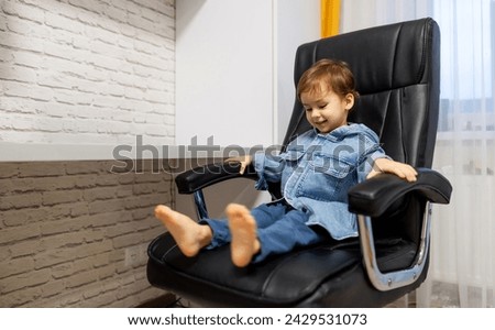 Little boy is sitting in chair at home and watching cartoons on laptop. The concept of children's entertainment online learning home schooling.