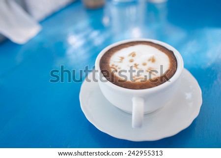 hot coffee kitty foam on blue table