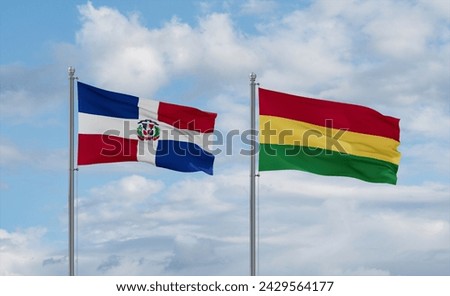 Bolivia and Dominican flags waving together on blue cloudy sky, two country relationship concept