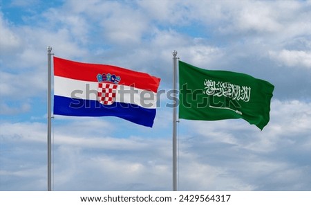 Croatia and Saudi Arabia flags waving together in the wind on blue cloudy sky