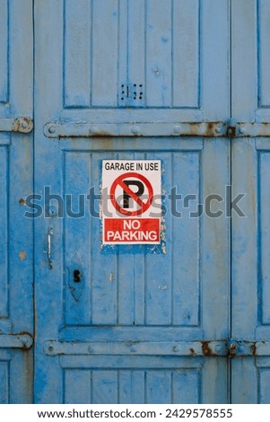No parking sign on the blue wooden garage door