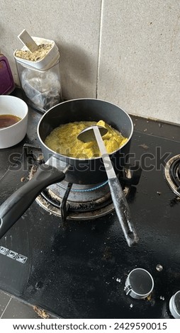 a picture of hot chili yellow curry with coconut milk being cooked on the stove