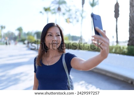 Young asian woman smiling confident making selfie by the smartphone at park