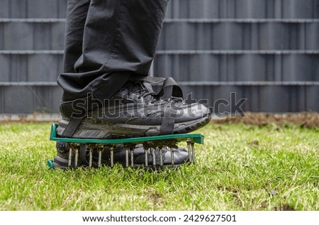 Close-up of lawn aerating shoes with metal spikes. Royalty-Free Stock Photo #2429627501
