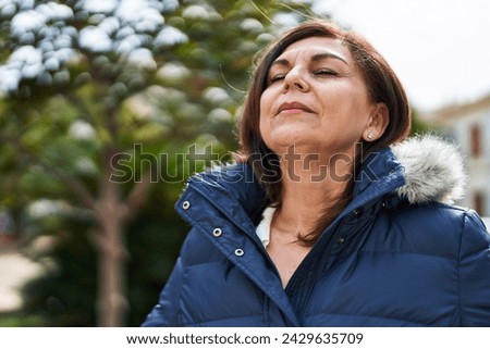 Middle age woman breathing with closed eyes at park Royalty-Free Stock Photo #2429635709