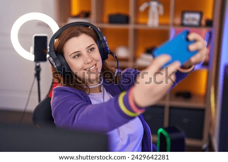 Young beautiful plus size woman streamer smiling confident make selfie by smartphone at gaming room