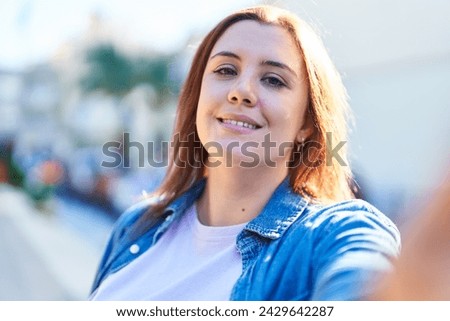 Young beautiful plus size woman smiling confident making selfie by camera at street