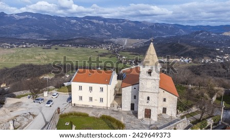 Aerial view of the charming village of Grobnik near Rijeka, Croatia, showcasing an old fortress atop a hill and a quaint church