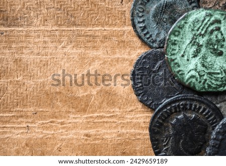Ancient Roman coins on vintage background, top view, old worn bronze money and copy space close-up. Concept of Rome, Empire, texture, collection, artifact, civilization and history.