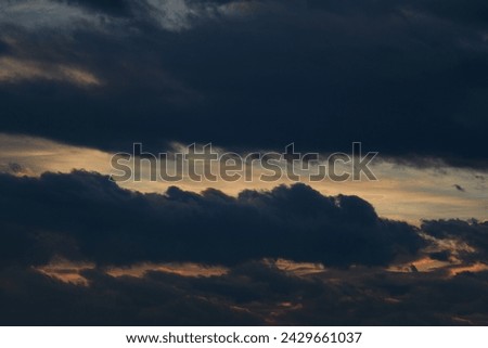 Dark evening sky. Bad weather. Fluffy clouds. Light breaks through the clouds. Universal horizontal photo. The background picture. 