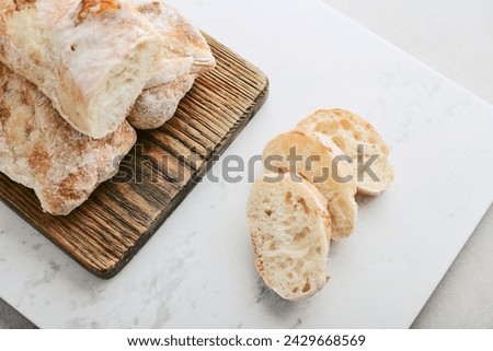 Rustic French sourdough baguettes on wooden cutting board top view