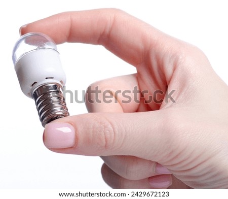 lamp E14 energy-saving compact fluorescent in hand on white background isolation Royalty-Free Stock Photo #2429672123