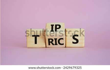 Tips and Tricks symbol. Wooden cubes with words Tricks and Tips. Beautiful pink background. Business and Tips and Tricks concept. Copy space